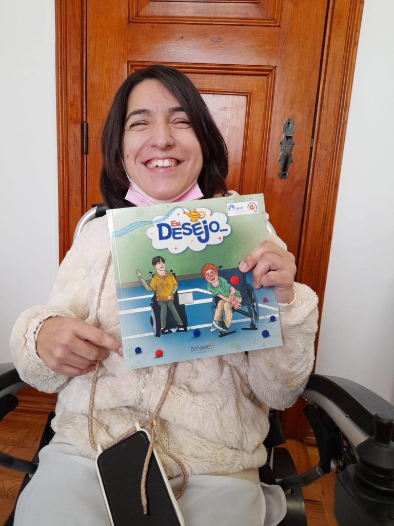 Smiling Lady showing a book on wheelchair